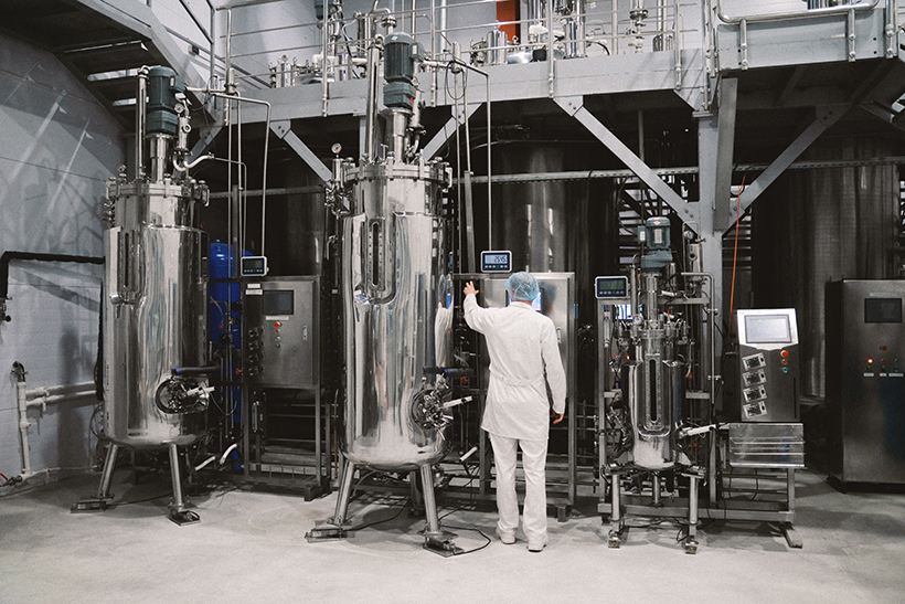 Industrial engineer standing in front of a chemical plant, producing organic fertilizers. Industrial worker controlling production and checking quality